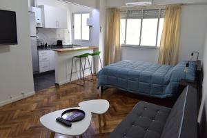 布宜诺斯艾利斯Belgrano Cozy Suite的厨房以及带床和桌子的客厅。