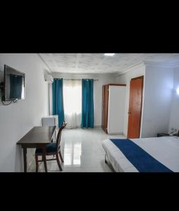 科纳克里HÔTEL MARIADOR PARK的一间卧室配有书桌、一张床和一张桌子