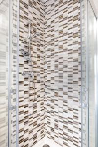 姆西达Msida Central Suites的带淋浴的浴室(带瓷砖墙)