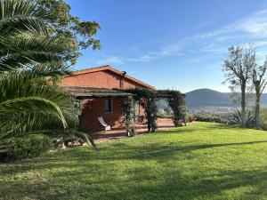 蒙蒂亚诺Podere Cavone - Casale degli Ulivi的一座房子,旁边是一片绿色草坪