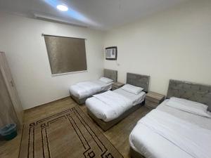 麦地那شقق الفتح الخاصة Al-Fateh Private Apartments的一间设有两张床的客房,墙上挂有黑板