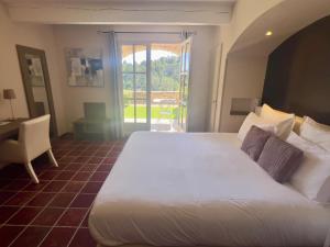 Aragon贝日里餐厅酒店的卧室配有白色的床、书桌和窗户。