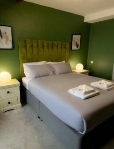 班戈Nomi Rooms & Restaurant的一间卧室设有一张带绿色墙壁的大床