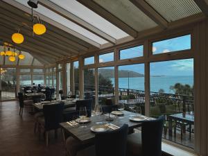 班戈Nomi Rooms & Restaurant的一间带桌椅的海景餐厅