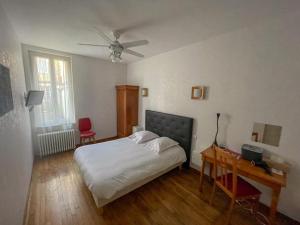 讷韦尔维尔顿酒店的一间卧室配有一张床、一张桌子和吊扇