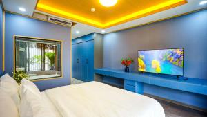 河内Hanoi Ben's Apartment and Hotel的卧室配有白色的床和平面电视。