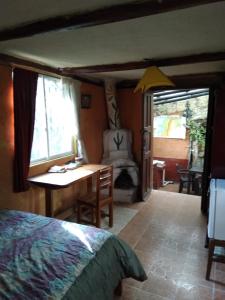 奥塔瓦洛Quinta El Quinde的一间卧室配有一张床、一张桌子和一把椅子