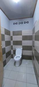 话毛生Sobey Laris Roomstay GUA MUSANG的一间带卫生间的浴室,位于带条纹墙的房间内