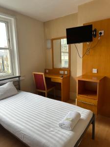 伦敦伯克利苑酒店 的一间卧室配有一张床、一张书桌和一台电视