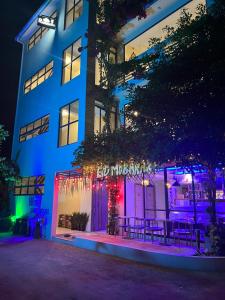 呼拉Wish Guesthouse的前面有紫色和蓝色的灯光的建筑