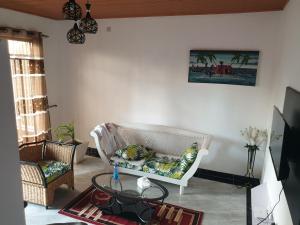 马林迪RAKA HOLIDAY HOMES的客厅配有白色的沙发和桌子