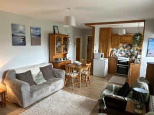 格伦贝赫Glenbeigh Holiday Cottage - Tigin Mamo的带沙发的客厅和厨房