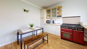 巴塞尔顿Stunning 3-Bed House in Basildon的厨房配有红色炉灶和桌子