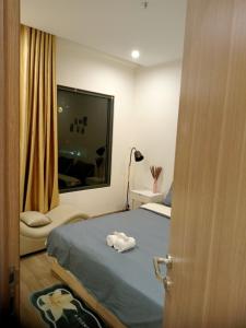 Gò CôngFT homestay at Vinhome Grand Park HCM的一间卧室配有一张床和一个带毛巾的窗户