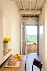 马利亚诺因托斯卡纳Casale Sterpeti的一间带木桌和窗户的用餐室