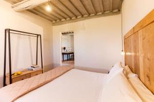 马利亚诺因托斯卡纳Casale Sterpeti的一间卧室配有一张带木制床头板的床