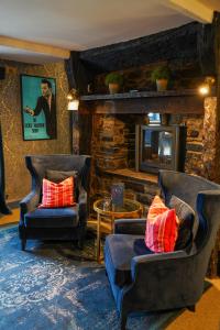 克里克豪厄尔The Bluebell Country Inn, Crickhowell的客厅配有两把椅子和壁炉