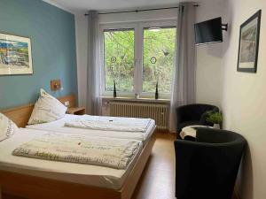 特拉本特拉巴赫Pension Bartz的卧室配有床、椅子和窗户。