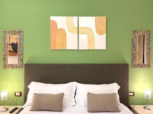 锡拉库扎卡萨瑟莱斯特公寓的卧室配有一张床,墙上挂有两幅画