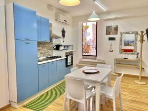 锡拉库扎卡萨瑟莱斯特公寓的厨房配有蓝色橱柜和桌椅