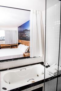 尤西德福拉Trade Hotel的一间带大镜子和浴缸的浴室