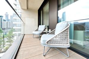 伦敦Elegant and Modern Apartments in Canary Wharf right next to Thames的市景阳台配有两把椅子