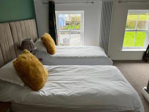 斯旺西Willow Mews的卧室内的两张床和泰迪熊
