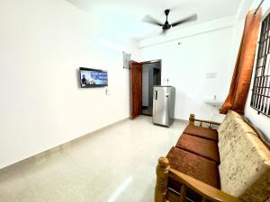 钦奈Sishya Service Apartment- 1bhk, IT Expressway, Thoraipakkam, OMR, chennai的带沙发和冰箱的客厅