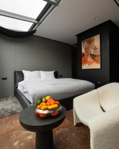 普里兹伦Morea Hotel的一间卧室配有一张床,桌上放着一碗水果