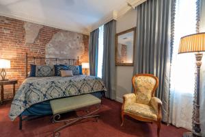 新奥尔良Quarter House Suites的一间卧室配有一张床和一把椅子
