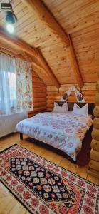 RozavleaCasa Ilies的木制客房内的一间卧室,配有一张床