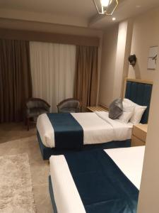 阿莱曼Coast Hotel的酒店客房设有两张床和窗户。