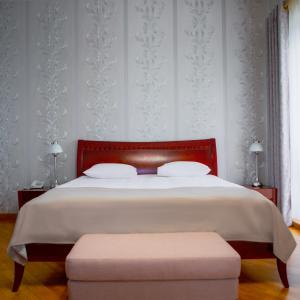 埃里温Latar Hotel Yerevan的一间卧室配有一张大床和红色床头板