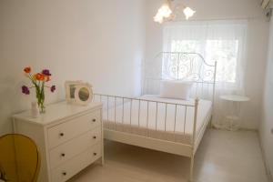 帕里斯特M&M apartment & rooms的白色卧室设有婴儿床和窗户