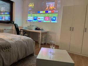 美因河畔法兰克福Private room with large bed -Netflix and projector的配有床、桌子和屏幕的房间