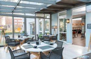 柏林柏林市南莱昂纳多精品酒店的餐厅设有桌椅和窗户。