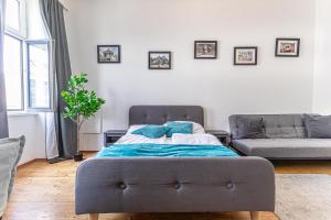 维也纳Stylish 1BR Apartment- Near Westbahnhof U3&U6的一张带蓝色枕头的床,位于一个沙发的房间