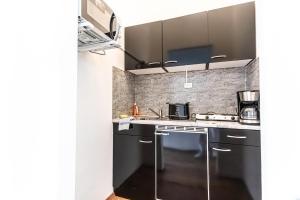 维也纳Stylish 1BR Apartment- Near Westbahnhof U3&U6的厨房配有黑色橱柜和炉灶烤箱。