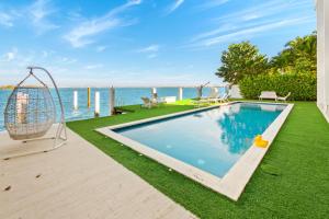 迈阿密Experience Opulence Your Exclusive Waterfront Sanctuary in Miami Beach的游泳池旁设有秋千