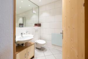 施库尔Chasa Mayer的一间带水槽、卫生间和镜子的浴室