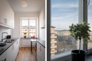 斯德哥尔摩Libevi 1的厨房配有白色橱柜、窗户和植物