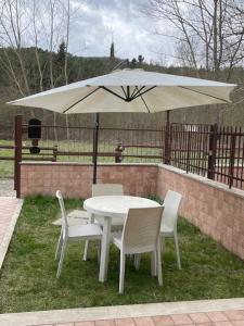 巴尼圣菲利波le piccole sorgenti的一张白色的桌子和椅子,配有雨伞