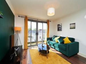 伯明翰Emerald Suite-Sleep 6-Long Stays - FREE PARKING的客厅设有绿色沙发和窗户。
