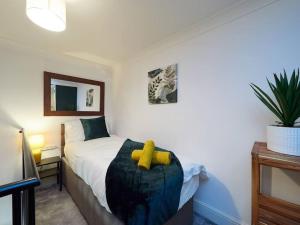 伯明翰Emerald Suite-Sleep 6-Long Stays - FREE PARKING的一间卧室,床上有一只黄色的填充动物