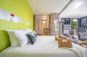勒拉芒坦Chalet étoilé BAYALOCATION的卧室配有白色大床和绿色墙壁