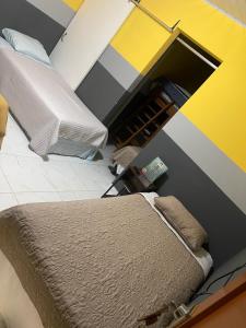 安赫莱斯镇Mirador Hotel Aoki的一间卧室设有一张床和黄色及灰色的墙壁
