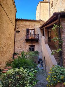 圣吉米纳诺La Torre Nomipesciolini的一座带阳台和楼梯的古老建筑