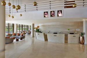 利雅德Marriott Riyadh Diplomatic Quarter的大堂设有带沙发和肖像的等候区