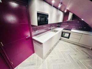 伦敦High Standard Room, Super Location的厨房配有紫色墙壁和白色橱柜