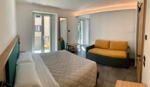 莱德罗Hotel Locanda Alla Perla的一间卧室配有一张床和一张沙发